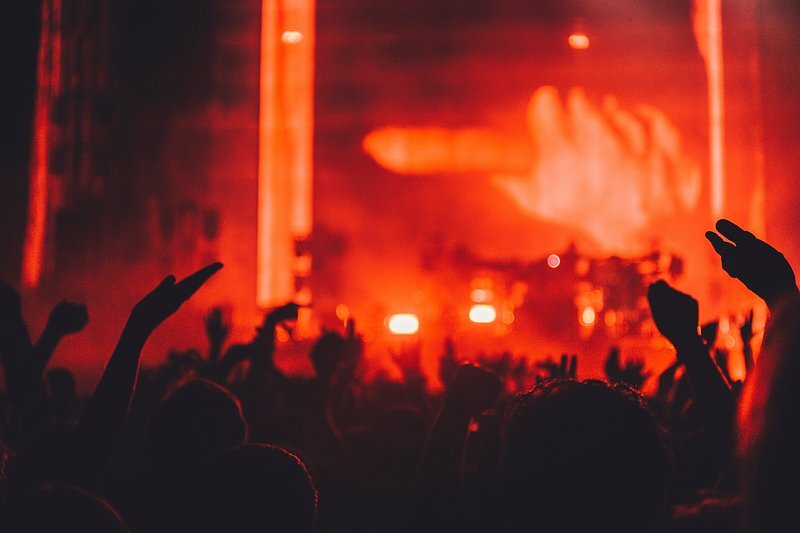 Crowd in a warehouse under a red light beam
